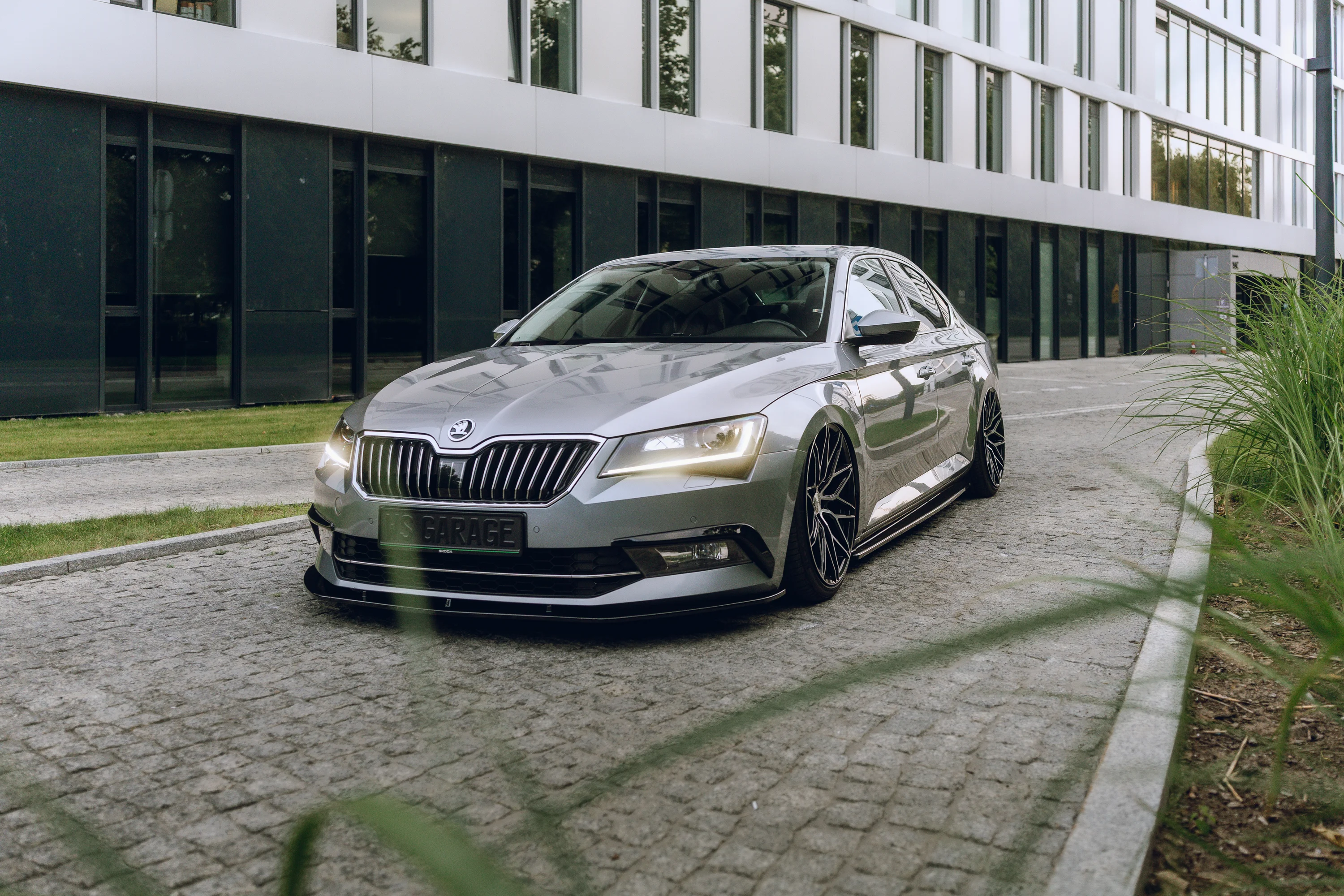 Škoda Superb przed nowoczesnym budynkiem